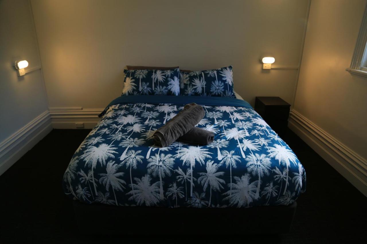 The Mansion Melbourne Hostel Exterior photo A bed with a duvet