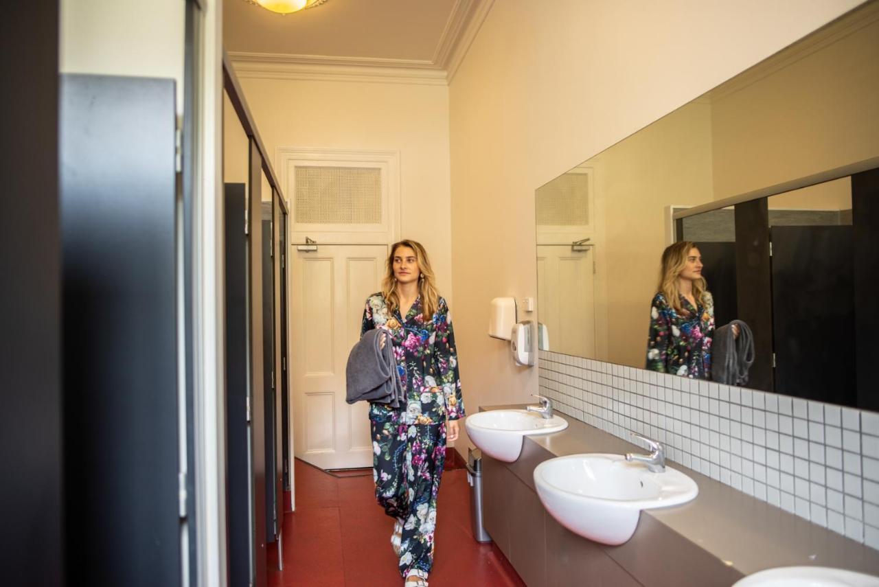The Mansion Melbourne Hostel Exterior photo A woman in a bathroom